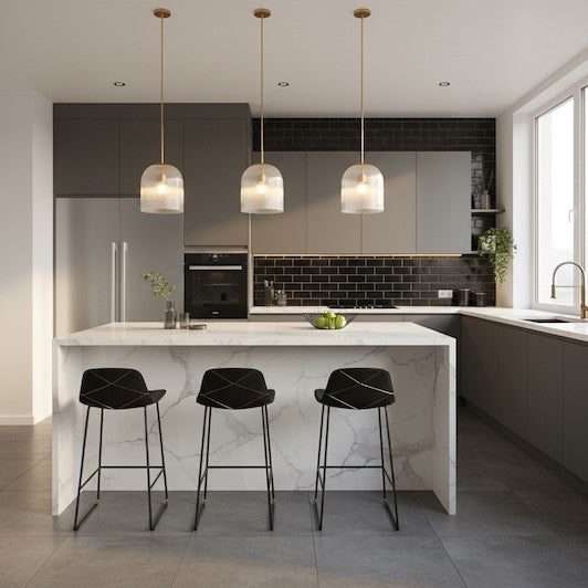 Three ribbed glass pendant lights with copper accents hanging over a white marble kitchen island in a luxury home.