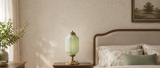Green textured glass table lamp proportioned beside a warm upholstered bed