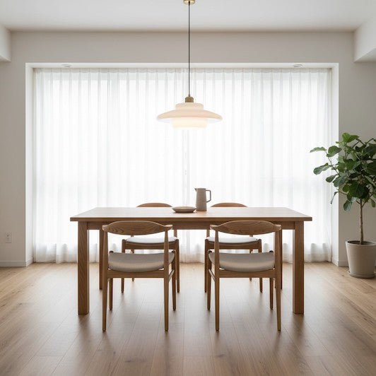 A modern minimalist dining room featuring a milk glass pendant light over a wooden table.