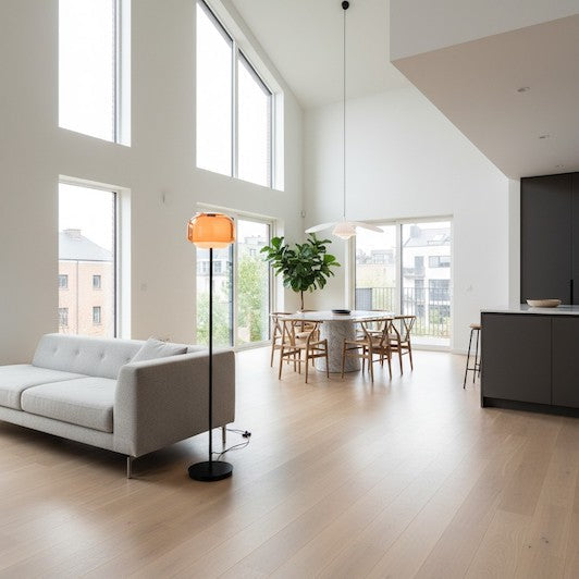Modern open-plan living room featuring a colored glass floor lamp providing visual balance.