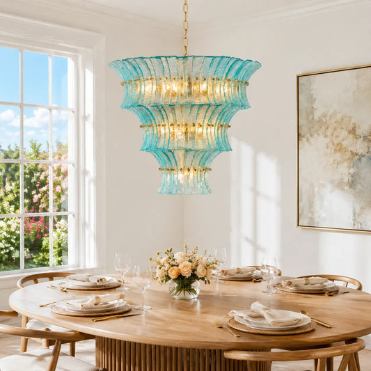Aqua textured glass tiered chandelier glowing above an oval dining table