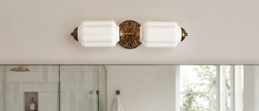 Milk glass and brass vanity light adding vintage character to a clean modern bathroom