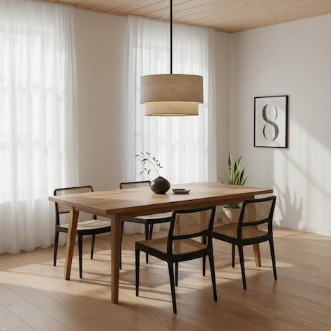 A Beck modern natural linen double drum chandelier hanging over a wooden dining table in a bright room.