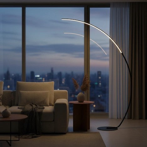 A modern living room featuring a sleek black LED arc floor lamp curving over a sofa.