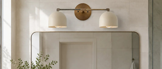 Two-light dome vanity fixture centered above a wide bathroom mirror
