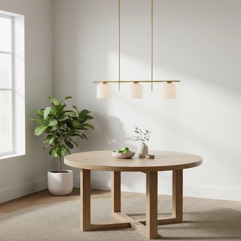 A large polished brass dome pendant light perfectly scaled over a round dining table in a modern home.