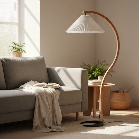 A stylish Scandinavian reading corner with a curved wood floor lamp and a grey sofa.