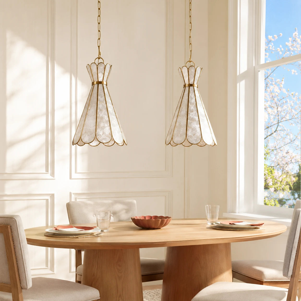 Two centered Mira Capiz shell pendant lights over a sunlit round dining table