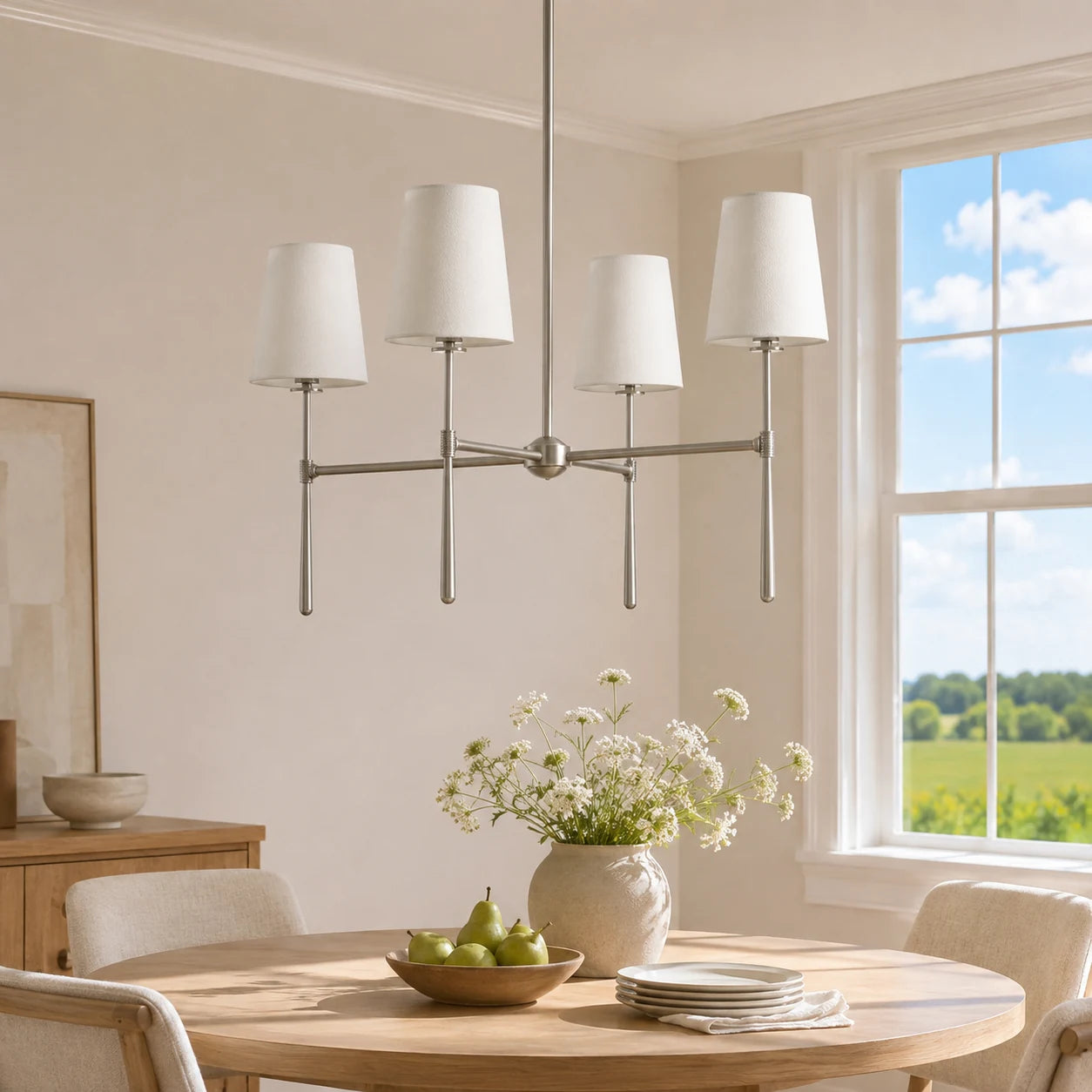 Nickel four-light chandelier above a round oak dining table