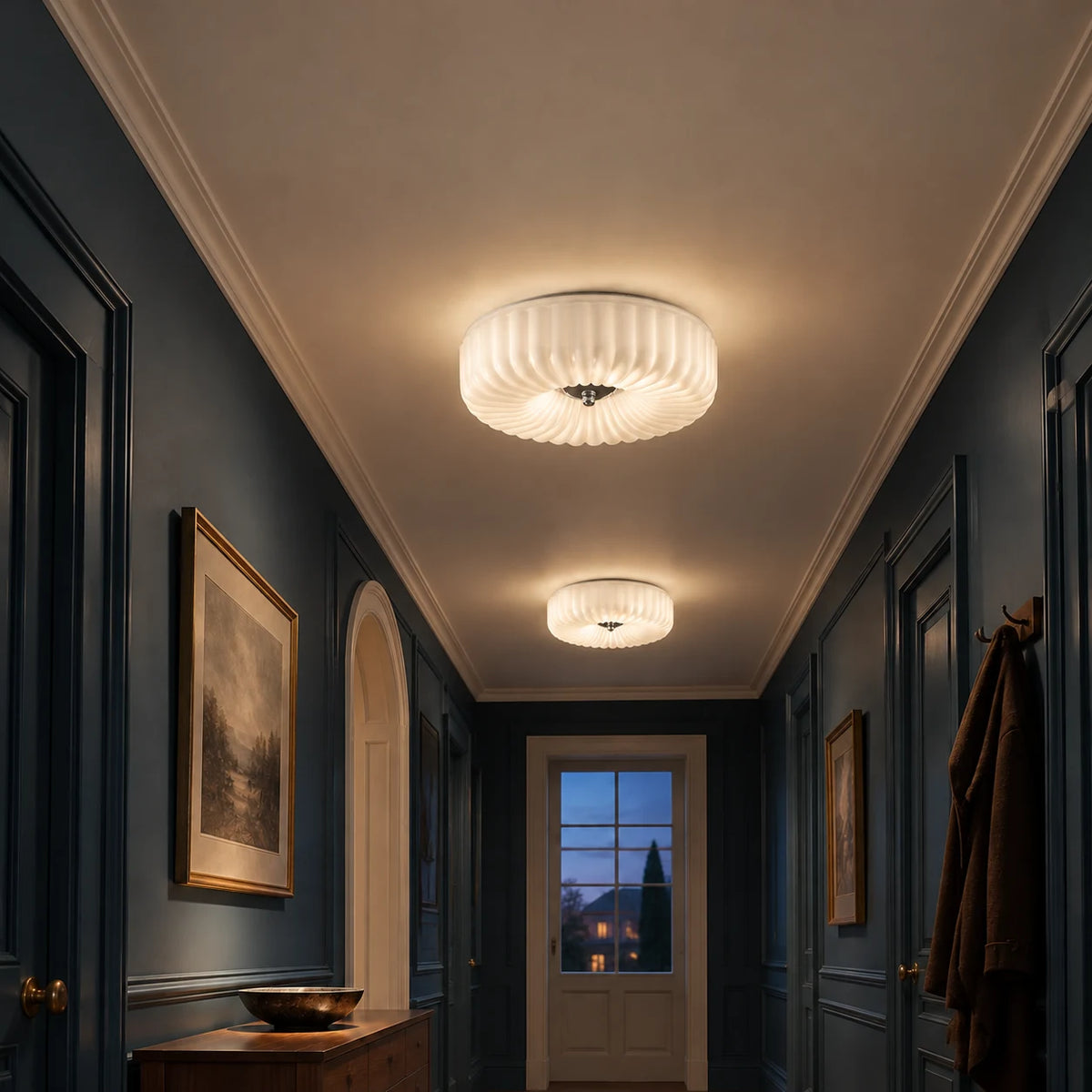 Pair of Maelis white glass flush mounts in an evening hallway