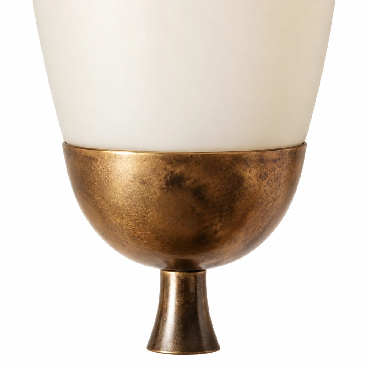 Macro of white glass shade meeting antique brass cup