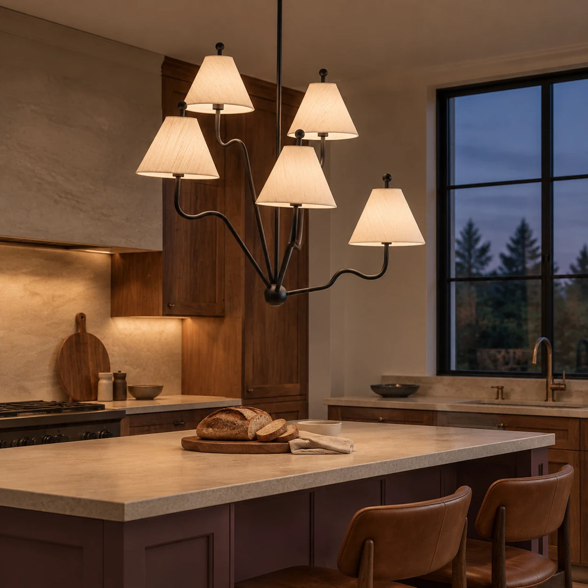 Lit black silk shade chandelier above a plum island in a walnut kitchen at blue hour