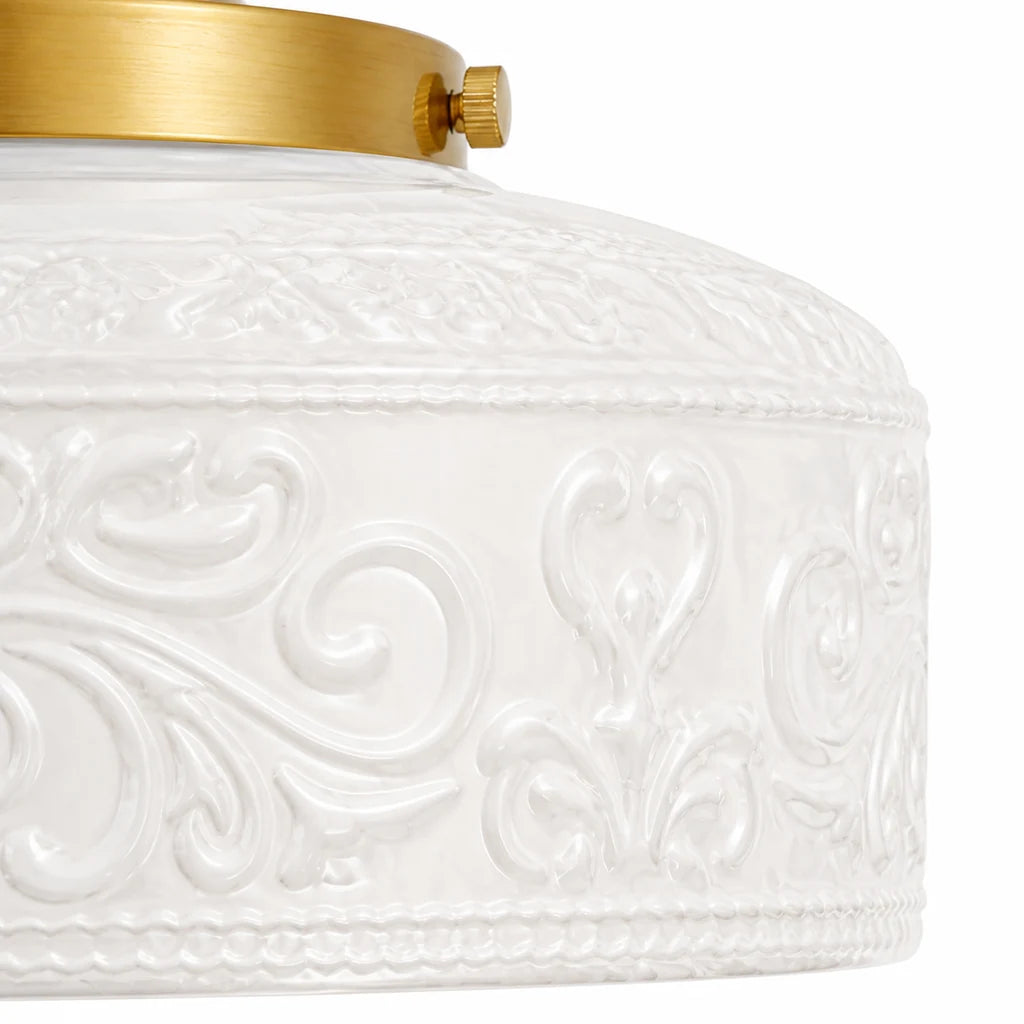 Macro detail of milky white embossed floral glass and gold side fastener