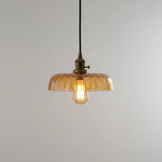 Vintage-style pendant light with amber glass shade on a plain background
