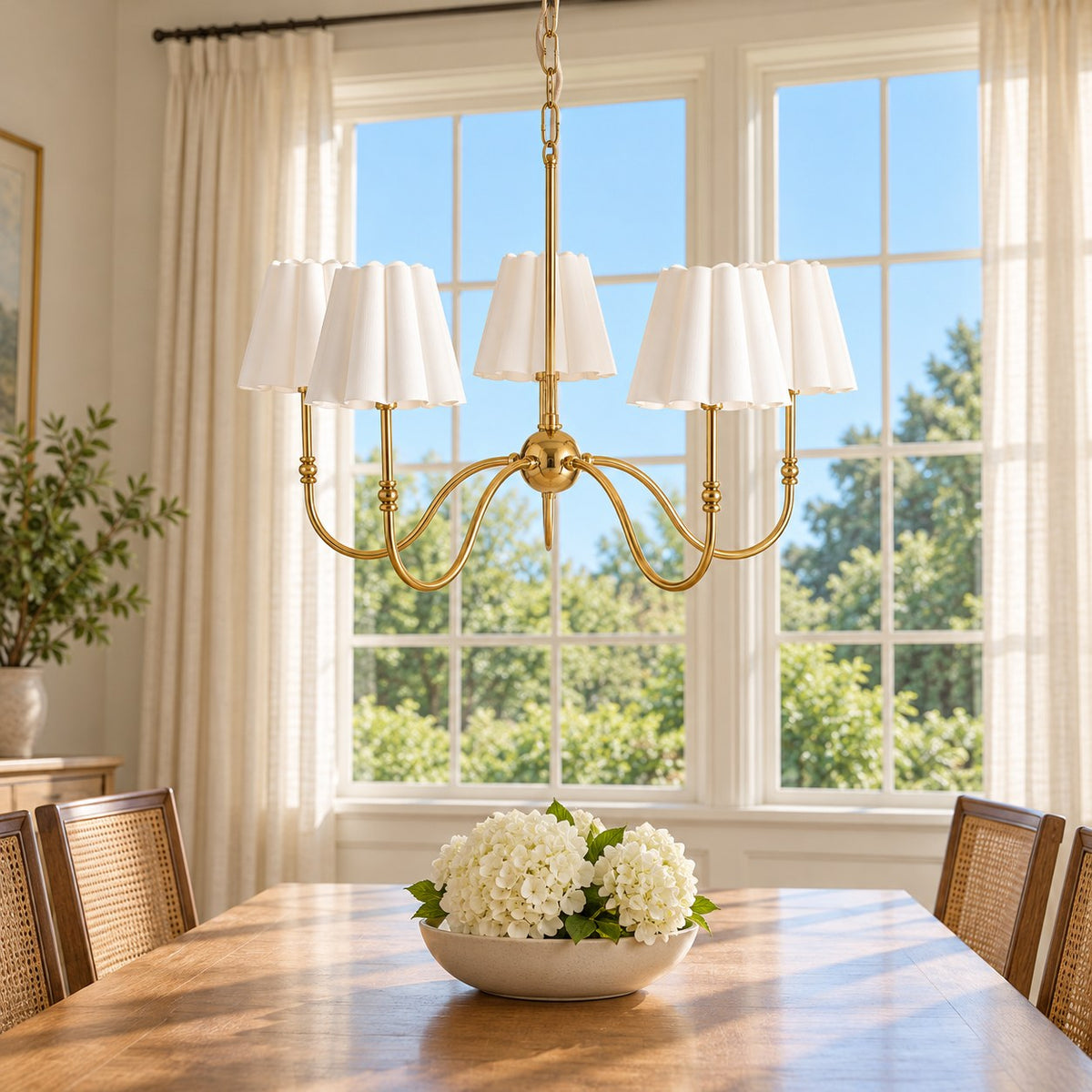 Aurelia five-light chandelier over a dining table with blue sky and green trees