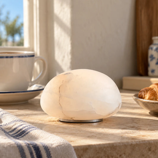 White cordless alabaster accent table lamp on a sunlit side table