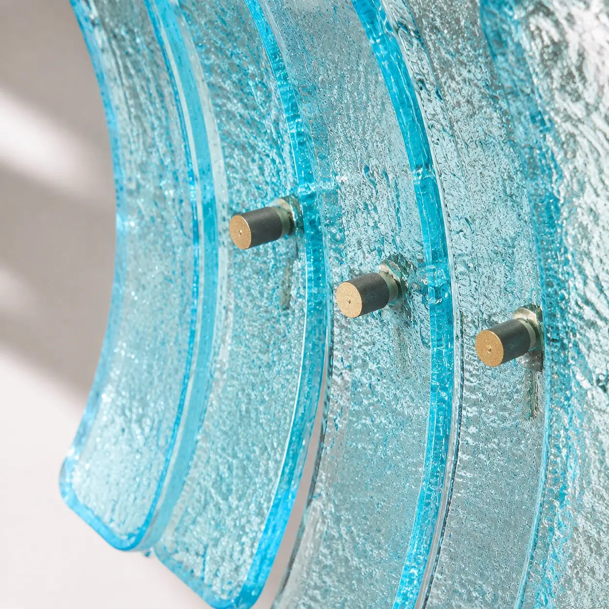 Close detail of aqua textured curved glass blades