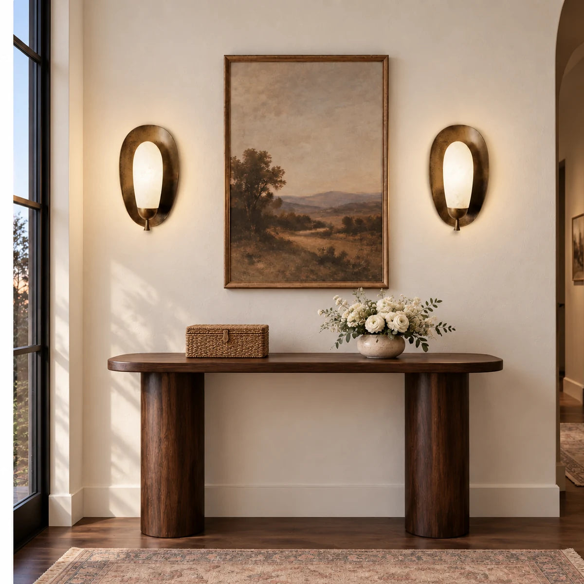 Pair of antique brass alabaster Maelle sconces on a white wall above a storage box